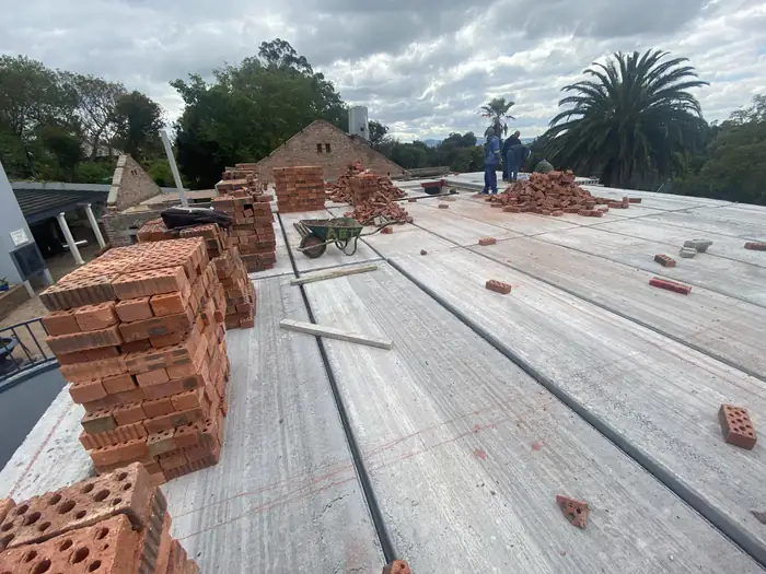 Bricks stacked across the slab at House Braeview, ready for the new floor above