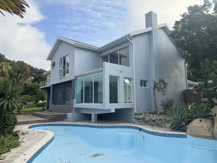 The rebuilt house seen across the pool and garden