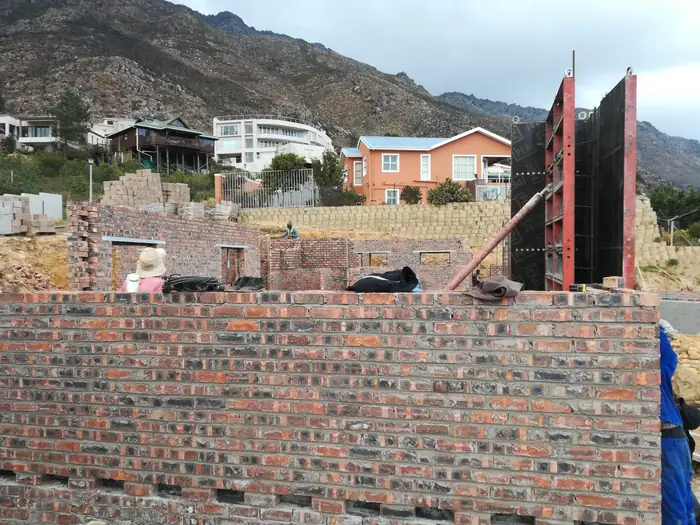 Brickwork going up at House Chapman with shuttering standing against it
