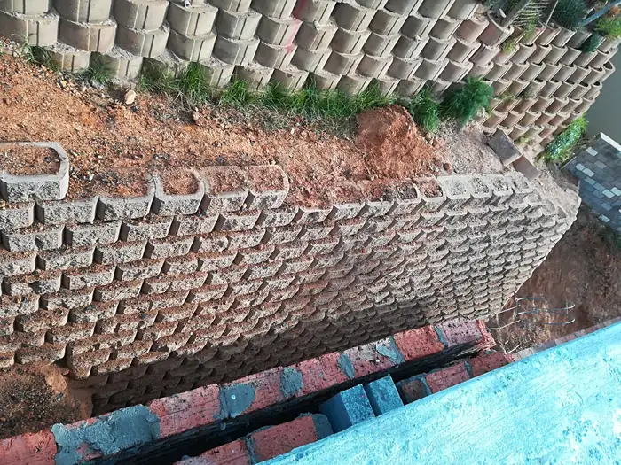 The engineered block retaining wall holding the bank at House Chapman