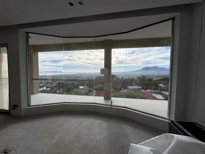 The curved glass wall of the main living level framing the view