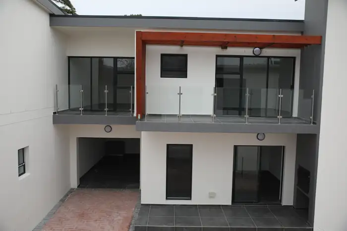The courtyard side, balconies on both levels above the covered parking