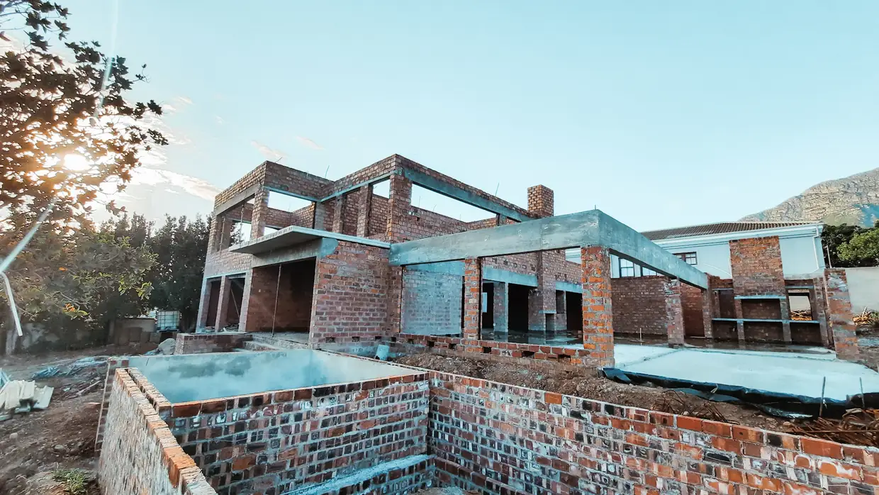 A brick shell taken to lock up, with the pool structure cast in the foreground