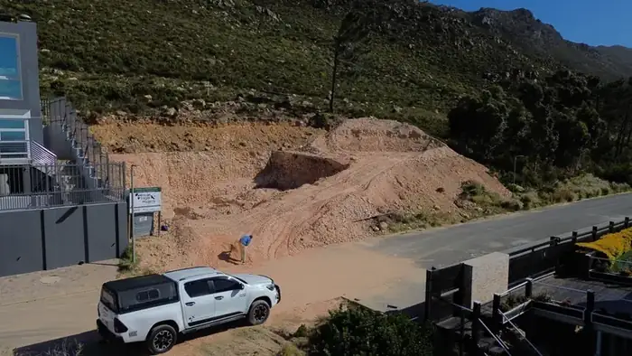 The excavation cut into the mountainside from the road, with the rock face exposed