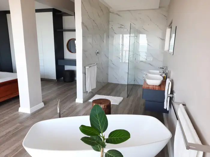The freestanding bath set against full height marble-look tiling