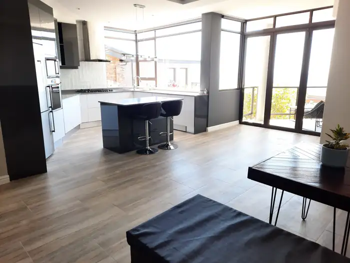 The open plan kitchen and living area with corner glazing onto the bay